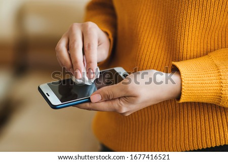 Similar – Image, Stock Photo Woman disinfecting phone with antiseptic wet wipe. Antiseptic napkin to prevent spread of germs, bacteria and coronavirus. Coronavirus prevention. Prevent illness coronavirus after public place.