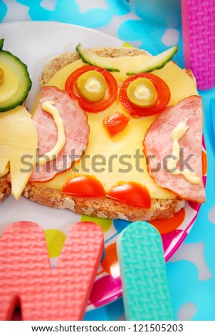 funny sandwich with owl made from cheese,sausage and vegetables for child