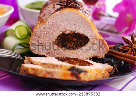 roasted pork loin stuffed with prune and spices on festive table
