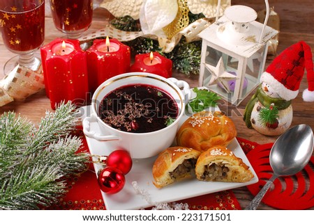 traditional red borscht in cup and yeast pastries stuffed with mushrooms for christmas eve supper
