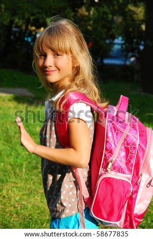 schoolgirl with pink backpack after lessons going home