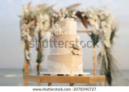 Wedding cake at a beach wedding on the background of a beautiful arch for an exit ceremony. ストックフォト © 