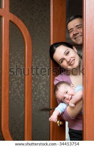 a happy family of three is looking out of the door