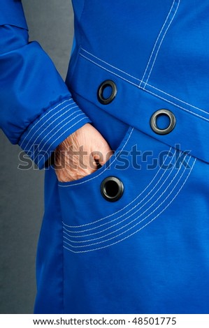 Senior, the woman in a beautiful blue raincoat.