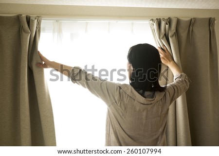 The woman who opens a curtain