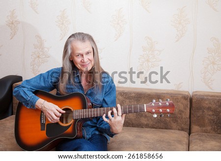 elderly man playing the guitar