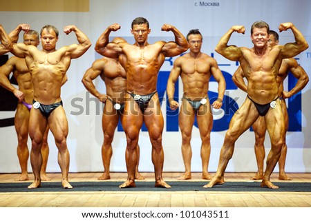 MOSCOW - APRIL 16: A.Sobolev, A.Solomatov, O.Sharikov (front raw) pose on the stage at the Open Championship and Cup of Moscow of bodybuilding, fitness, bodyfitness, April 16, 2011, Moscow, Russia.