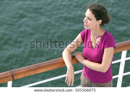 young woman traveling on ship looks into distance