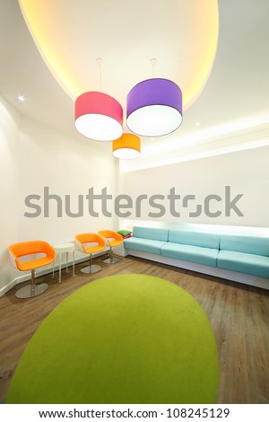 Empty lit room with bright armchairs, soft couches and lamps.