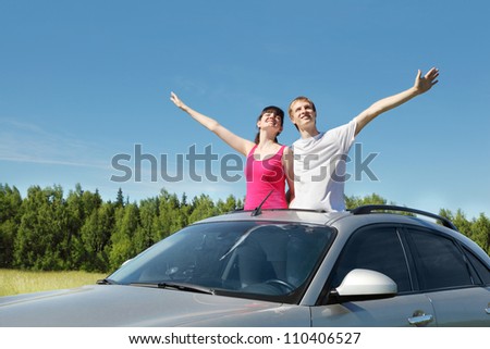 Husband, wife arrange hands in hatch of car in field