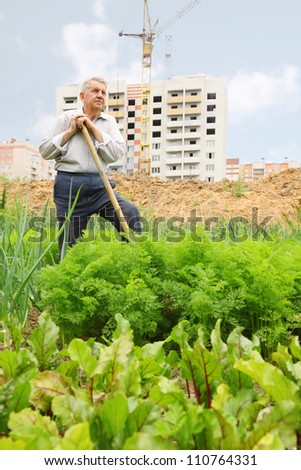 Grandfather pose with shovel on field near construction yard