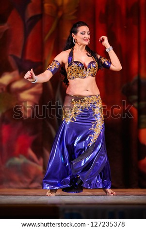 MOSCOW - JAN 28: Participant of Bellydance Superiority of Moscow in blue-gold suit dances on stage of  Red October Culture Palace,Jan 28, 2012, Moscow, Russia.