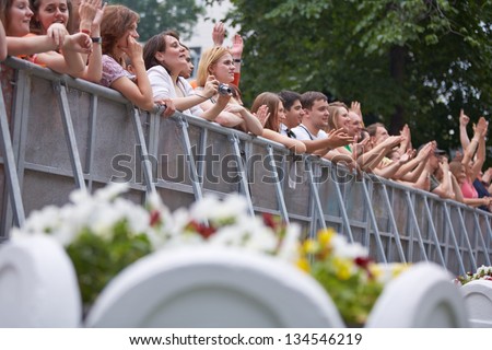 MOSCOW - JUN 23: People stand and applaud at fence at concert of Chaif rock-band during VII traditional festival of live sound Music of Summer in Hermitage Garden, Jun 23, 2012, Moscow, Russia.