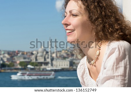 Beautiful woman in a landscape with a river and a mosque