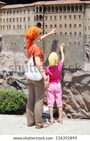 ISTANBUL - JULY 4: Mother and daughter touch walls of Sumela Monastry near Trabzon model in Miniaturk Museum, on July 4, 2012 in Istanbul, Turkey. Miniaturk museum has 105 exhibits.