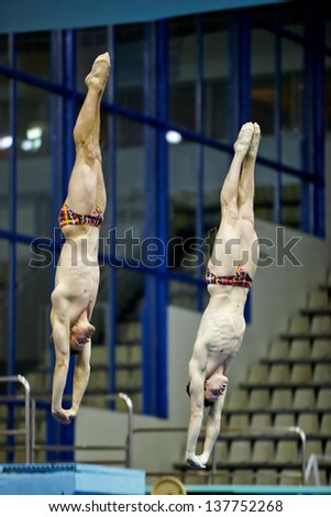 MOSCOW - APR 13: Athletes jump from diving-tower at competitions on syncronized springboard diving in Pool of SC Olympic of third phase of World Series of FINA Diving, April 13, 2012, Moscow, Russia.
