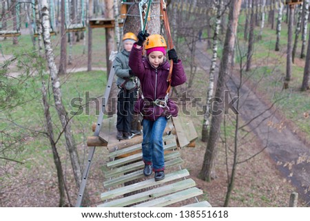 Little girl climber start the passage the ropes course