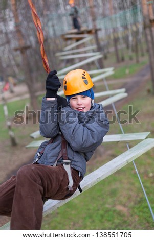 Little climber goes zigzag obstacle holding safety rope