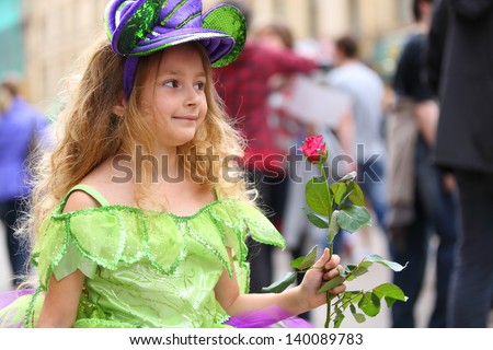 Happy little girl in fancy dress with a rose on the holiday of spring and bubbles Dreamflash