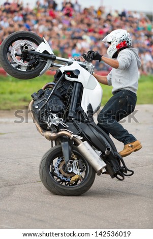 MOSCOW - AUG 25: Biker rides on the rear wheel on Festival of art and film stunt Prometheus in Tushino on August 25, 2012 in Moscow, Russia. The festival was organized in 1998.