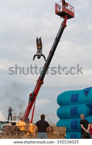 MOSCOW - AUG 25: Man jumping from a height into the burning box on Festival of art and film stunt Prometheus in Tushino on August 25, 2012 in Moscow, Russia. The festival was organized in 1998.