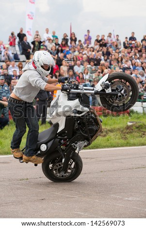MOSCOW - AUG 25: Biker rides on the rear wheel on Festival of art and film stunt Prometheus in Tushino on August 25, 2012 in Moscow, Russia. The festival was organized in 1998.