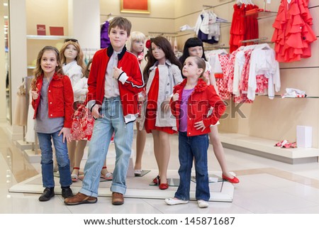 MOSCOW - MAR 18: Anya 7 years old, Jeanette 6 years old and Dmitry 10 years old trying on clothes together with mannequins in store children clothes Jakimanka on March 18, 2012 in Moscow, Russia.