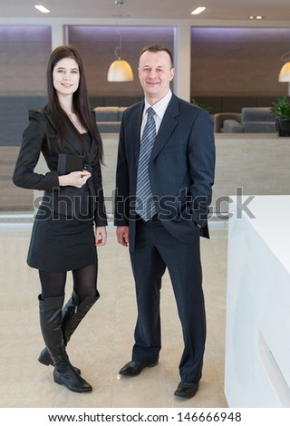 Man and woman in business suits standing at the reception