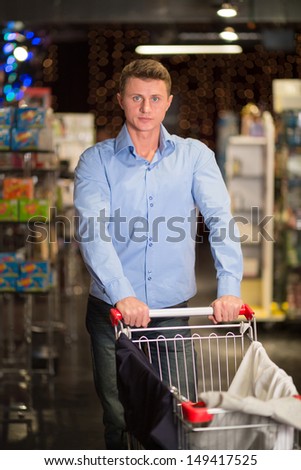 The young man in the store with a cart