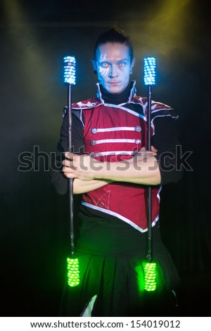 Performance of a man with a terrible pupils in samurai garb with glow sticks