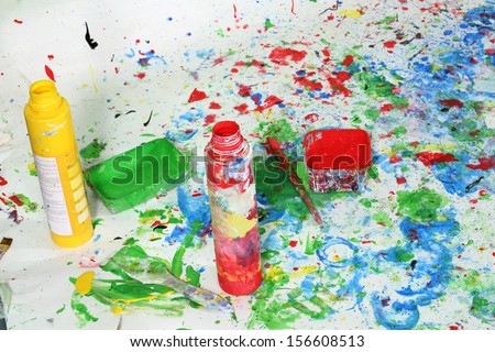 Open a bottle of paint on the floor with multicolored stains of paint