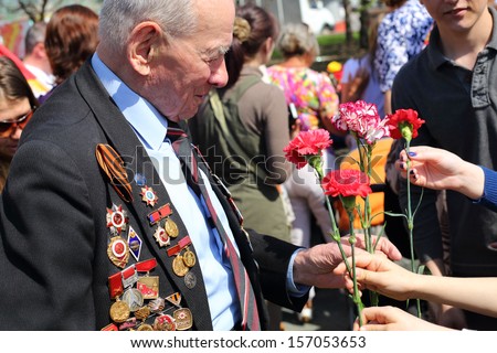 MOSCOW - MAY 9: People give flowers to veteran near Bolshoi theater, May 9, 2013, Moscow, Russia.  Every year on square in front of Bolshoi Theater traditionally gather veterans of Great Patriotic War