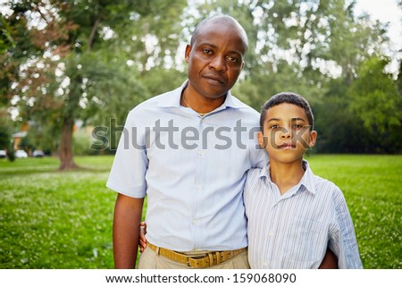 Half-length portrait of african father and son in summer park