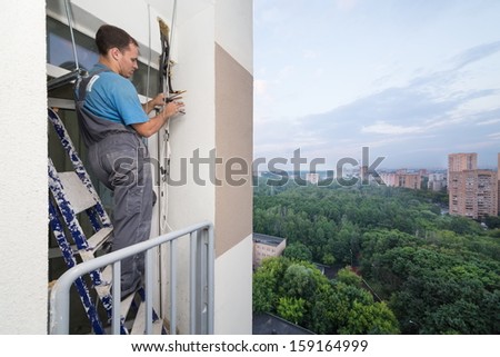 A worker sets tubes for split system air conditioner outdoor