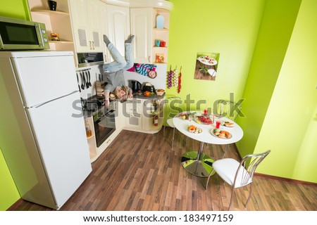 Mother and daughter sitting at shelves upside down in the kitchen