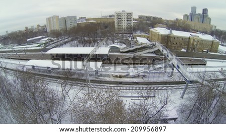 MOSCOW, RUSSIA - NOVEMBER 27, 2013: Snow-covered railway platform with a pedestrian bridge in the city, aerial view