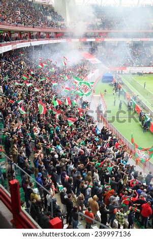 MOSCOW, RUSSIA - MAR 30, 2014: Fans launching smoke flare and waving flags at the stadium Locomotive