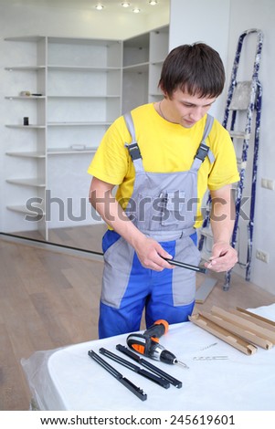 Man holding a fastening for doors sliding wardrobe