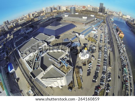 MOSCOW, RUSSIA - MAR 12, 2013: Church and car parking near Expo Center exhibition complex against cityscape at sunny day. Aerial view.