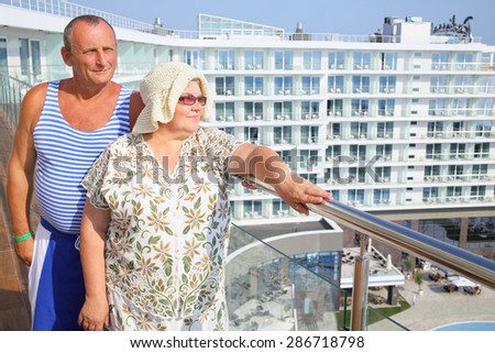 Portrait of elderly man in striped vest with wife on the balcony