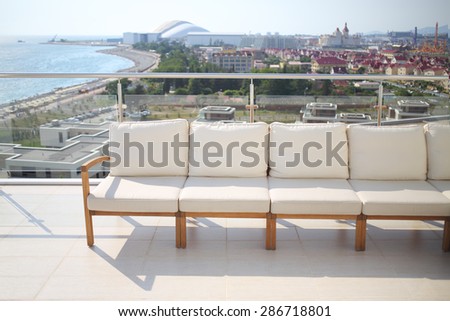 Seating area with beige sofa on the rooftop overlooking the city