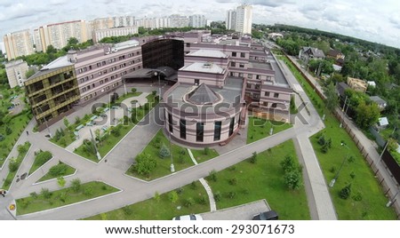 RUSSIA, MOSCOW - JUN 27, 2014: Aerial view edifice of diagnostic clinic near residential houses at summer cloudy day in Solntsevo. Photo with noise from action camera