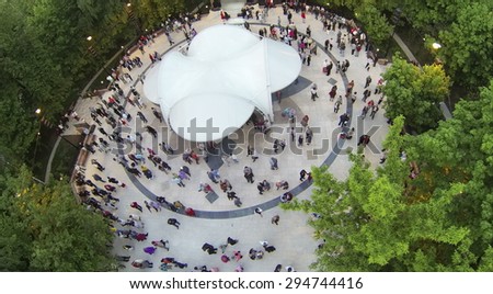 RUSSIA, MOSCOW - MAY 17, 2014: Many people dance on dancing ground in Sokolniki park at spring evening. Aerial view
