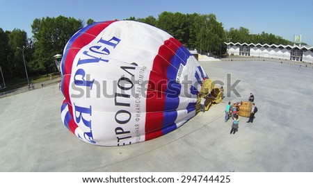 RUSSIA, MOSCOW - MAY 18, 2014: Fire flame goes during inflation of air balloon on square of park Sokolniki at spring sunny day. Aerial view