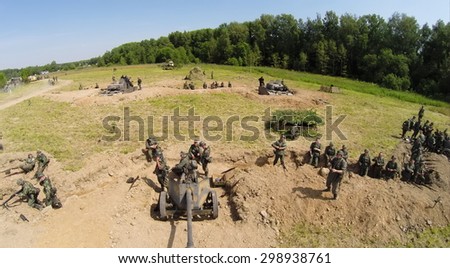 RUSSIA, MOSCOW - JUL 12, 2014: Soldiers in uniform of World War II stand near guns on battle field at spring sunny day. Aerial view. Photo with noise from action camera.