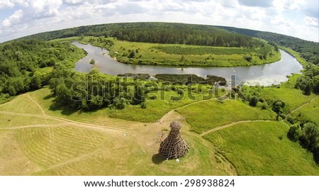 RUSSIA, NICOLA-LENIVETS - JUL 6, 2014: River shore with art object Lighthouse On Ugra in Wonderland Park during 9th Festival of landscape objects Archstoyanie. Photo with noise from action camera.