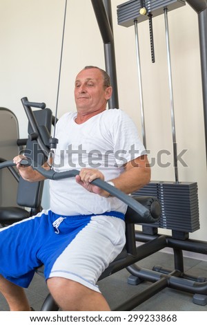 elderly man on weight machine in gym