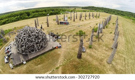 RUSSIA, NICOLA-LENIVETS - JUL 5, 2014: Visitors are near art object Universal Mind during 9 International Festival of landscape objects Archstoyanie. Aerial view. (Photo with noise from action camera)