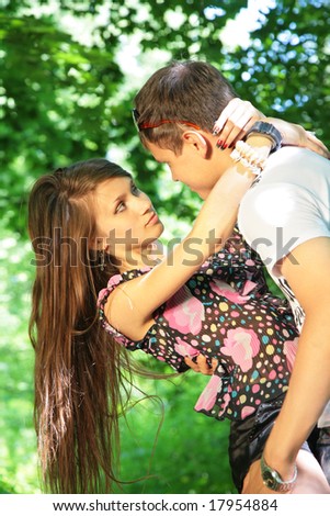 girl embraces guy for neck in wood