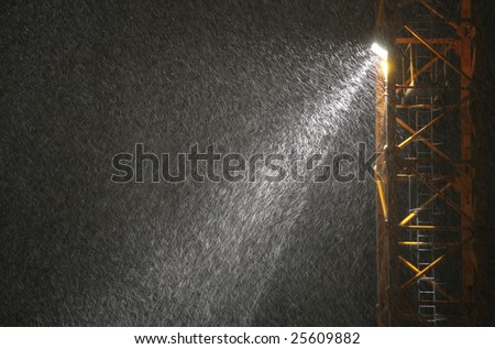 Snowfall in beam of projector at night